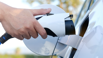 Electric vehicle charging plug connected to a car for home EV charging and energy-efficient transportation.