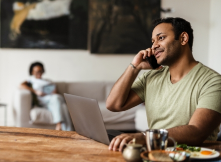 Man sitting at table talking on his mobile phone